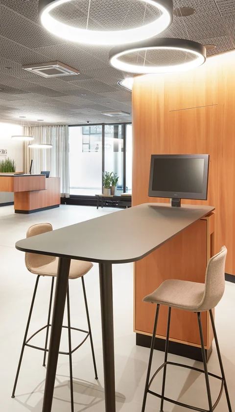 LOFT desktop Designmonitor von NOVIS auf einem Hochtisch für flexible Besprechungen.