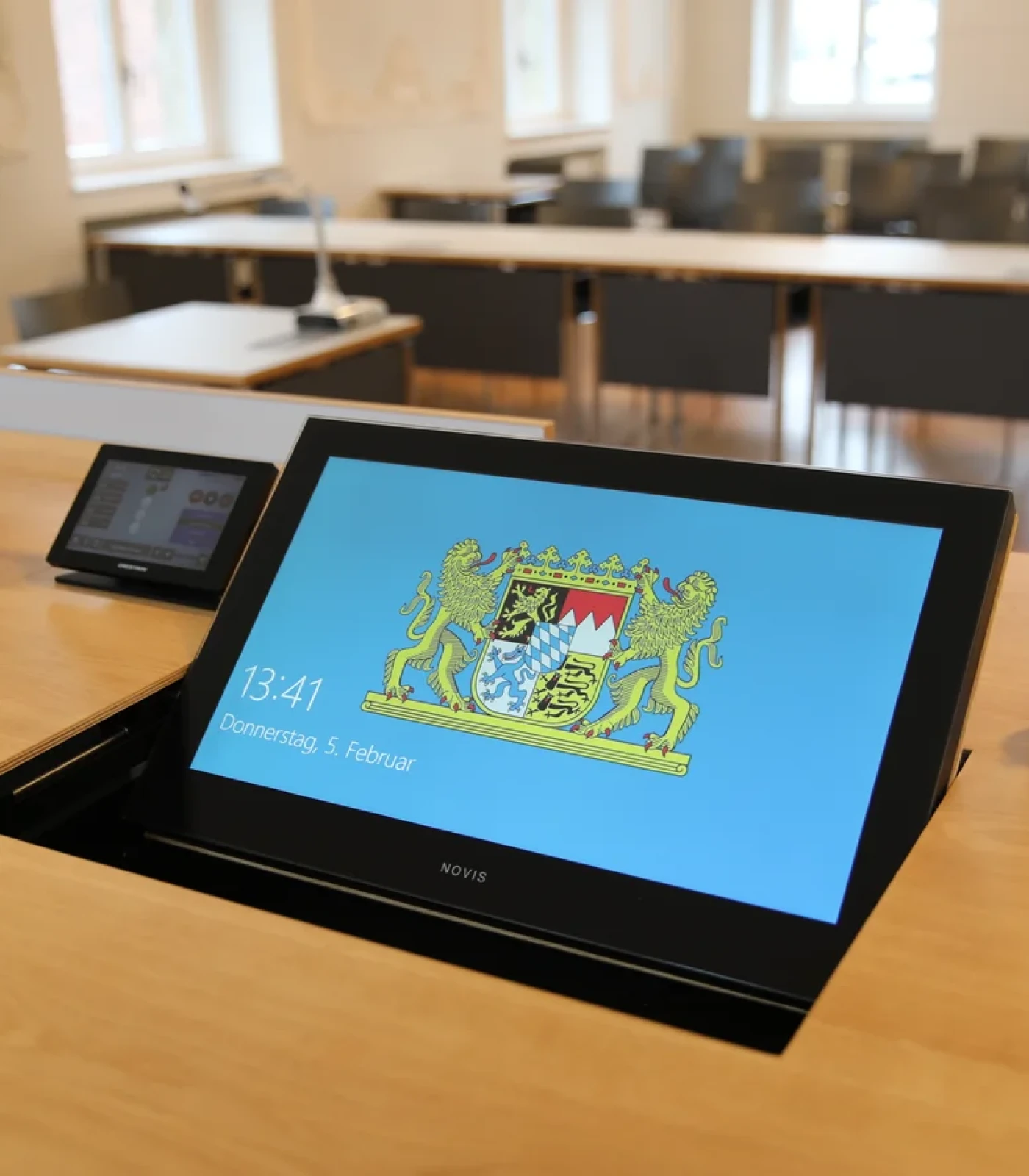 Der versenkbare Design Monitor LOFT fold in einem Konferenztisch.