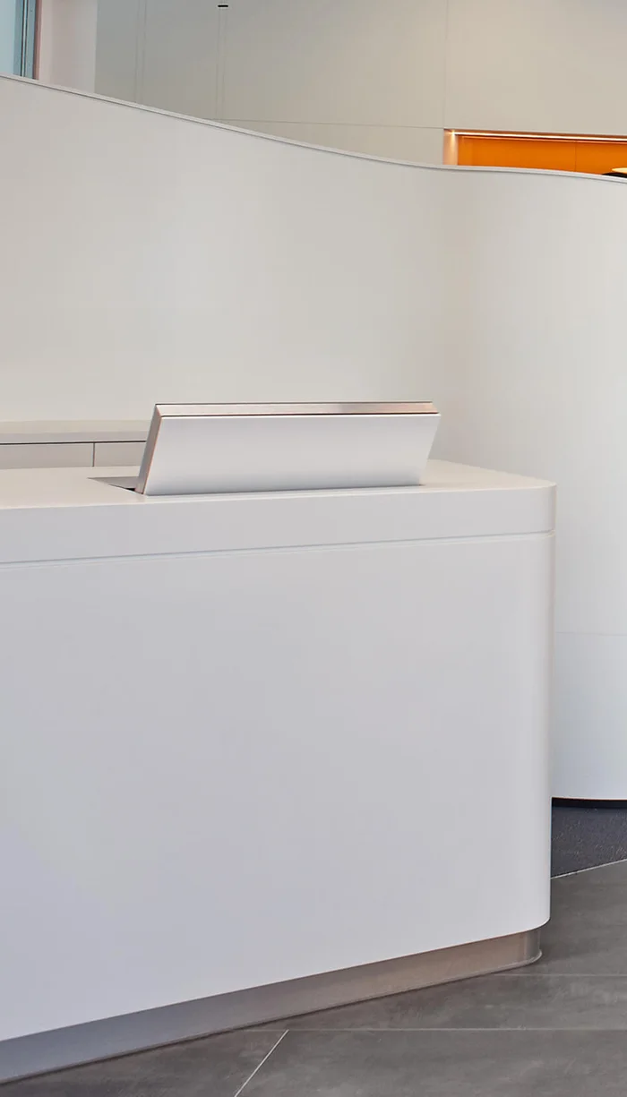 Der Novis LOFT fold versenkbarer Monitor am Empfang und in einer Empfangstheke