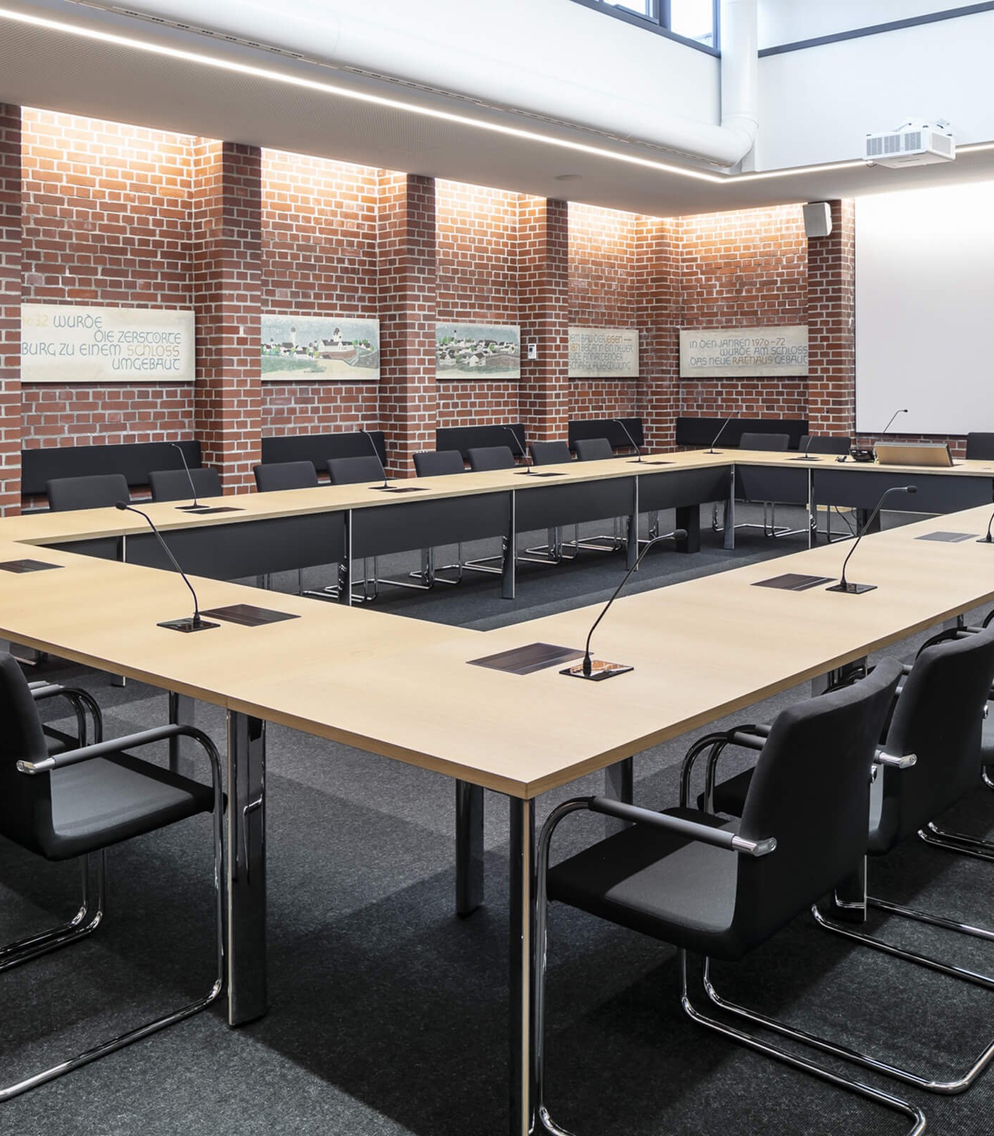 Ein großer Konferenztisch eines Rathauses mit unsichtbar integrierten Bildschirmen von Novis.
