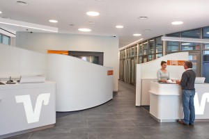 In der Lobby Halle der Volkbank diskret integriert unsere Tischeinbau Monitorlösung.