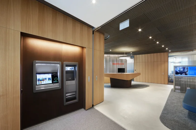 Unser Loft desktop Auftischmonitor präsentativ und ästehtisch in einer Bank. Der Monitor fügt sich nahtlos in seine Umgebung ein