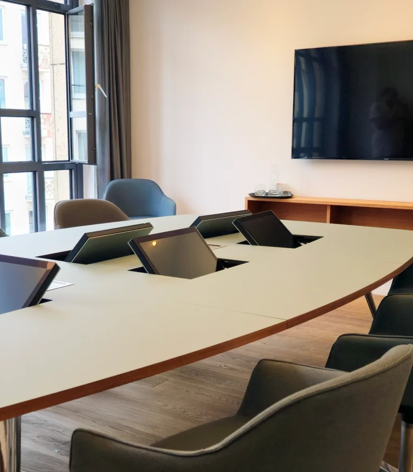Der versenkbare Monitor in einem Beurkundungstisch, geöffnet. An jedem Platz ein Bildschirm., alles perfekt im Blick